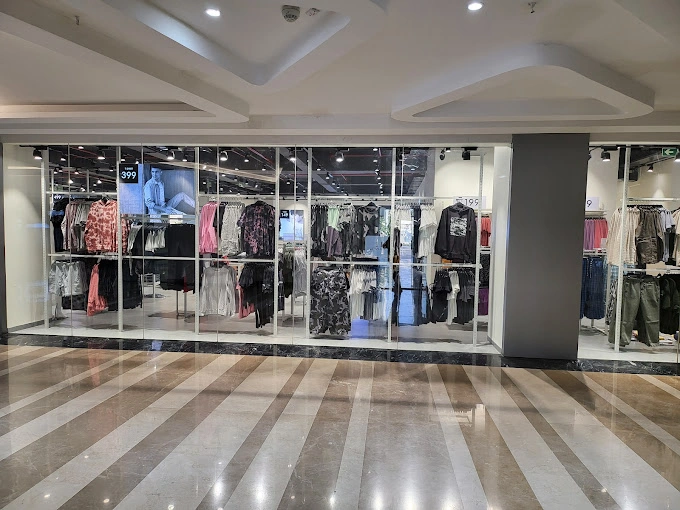 Store aisle with hanging garments and overhead lighting